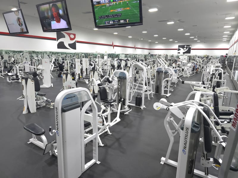 Modern gym with exercise machines and screens